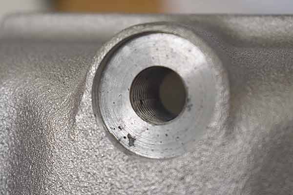 Porosity inside drain hole threads and outside of hole.