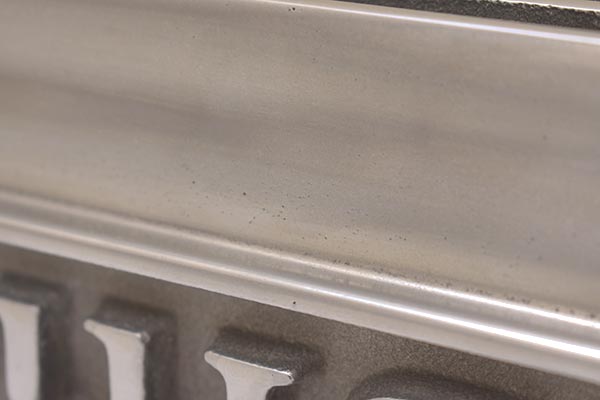 Lots of small porosity on front of second valve cover above script.
