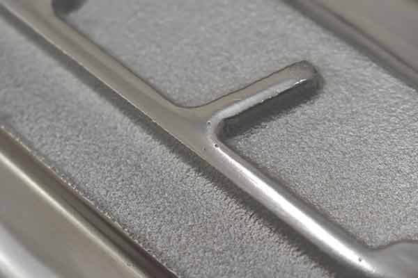 Small porosity spots on script of first valve cover.