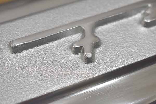 A small rough surface on script of first valve cover.