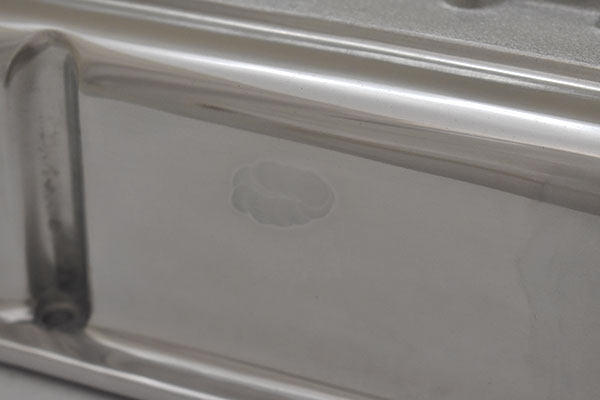 A dark spot on intake manifold side of first valve cover.
