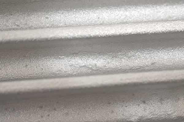 A third image of a casting blemish between fins on top of transmission pan.