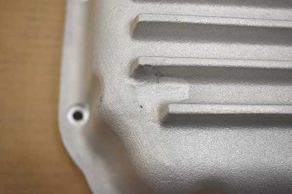 A welded area at on end of transmission pan.