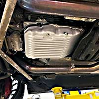 PML NAG2 transmission pan installed on a 2017 S63 AMG, view on left side, showing drain hole and plug